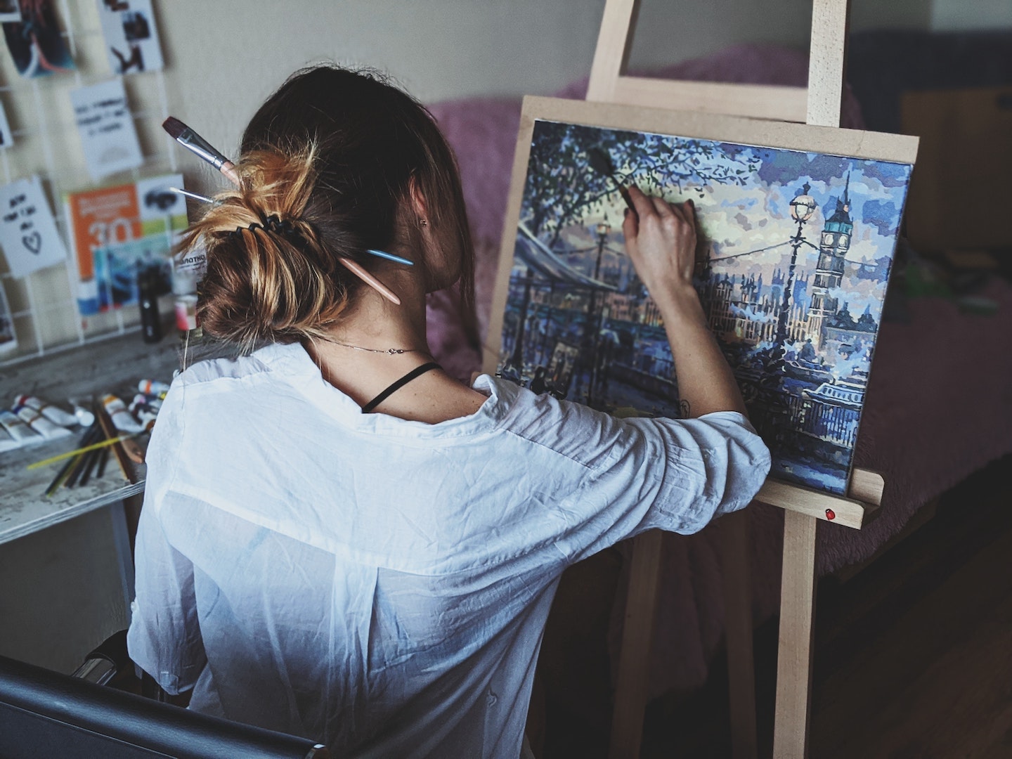 Image of a woman painting a canvas painting