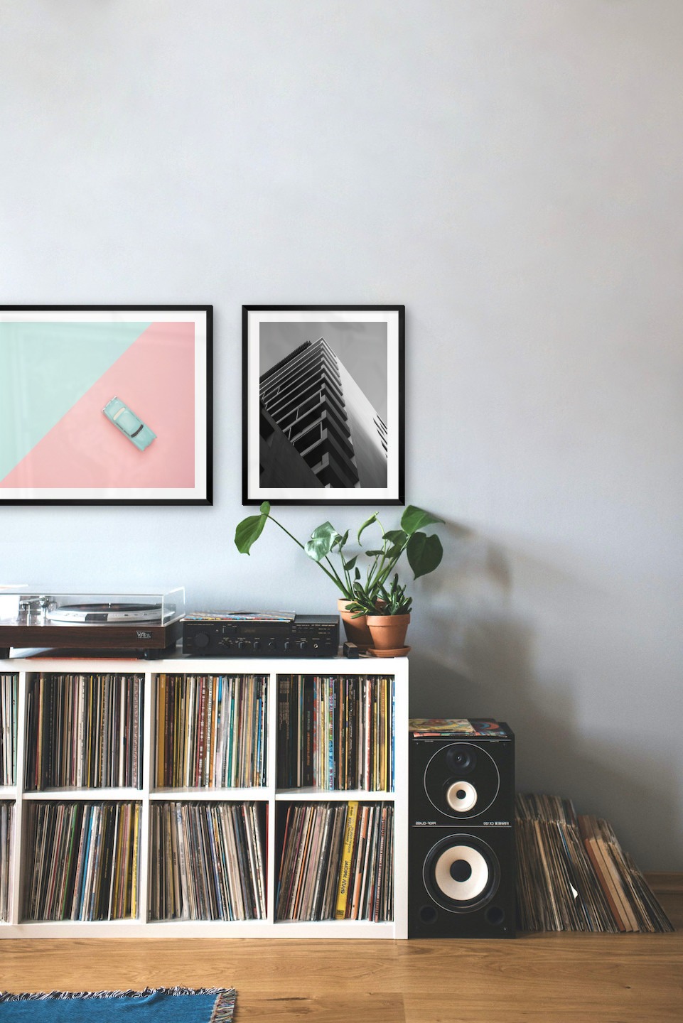 Gallery wall with picture frames in black in sizes 50x70 and 40x50 with prints "Blue car and pink" and "Black and white building"