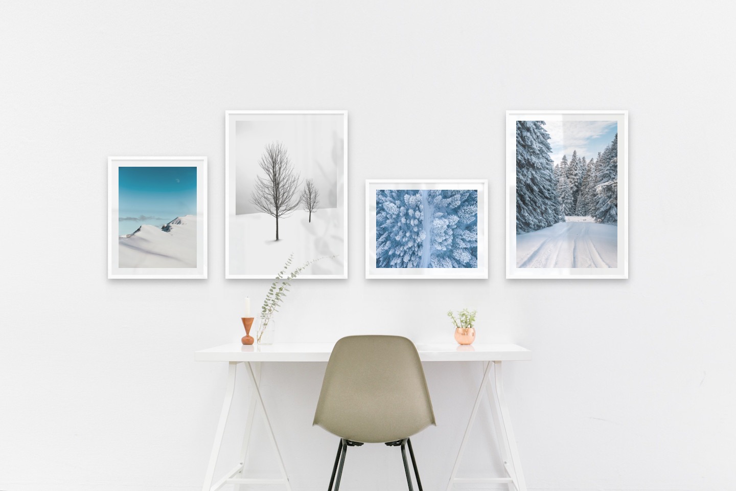 Gallery wall with picture frames in white in sizes 40x50 and 50x70 with prints "Snowy mountain peaks", "Trees in the snow", "Winter road from above" and "Snowy road"