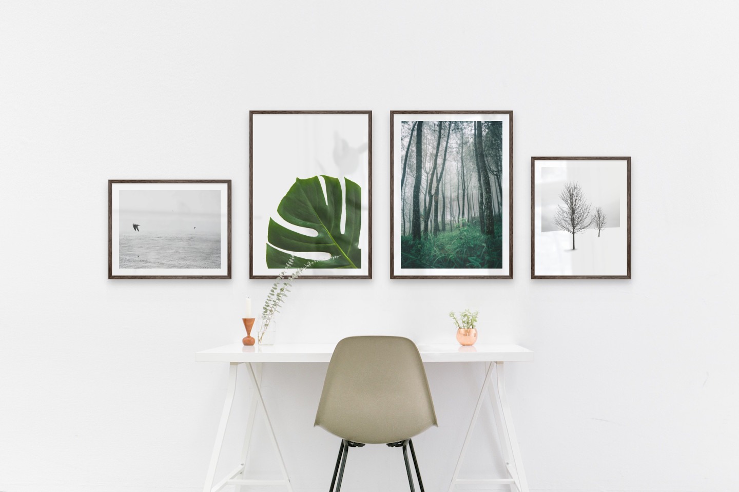 Gallery wall with picture frames in dark wood in sizes 40x50 and 50x70 with prints "Birds over the sea", "Plant", "Tall trees" and "Trees in the snow"