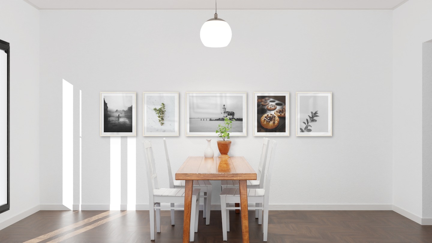 Gallery wall with picture frames in light wood in sizes 40x50 and 50x70 with prints "Rainy city", "Herbs", "Pier with building", "Cookies with chocolate" and "Twig"