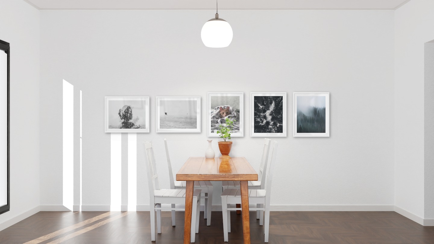 Gallery wall with picture frames in white in sizes 40x50 with prints "Trees and silhouette", "Birds over the sea", "Cat in felt", "Wooden tops and birds" and "Foggy forest"