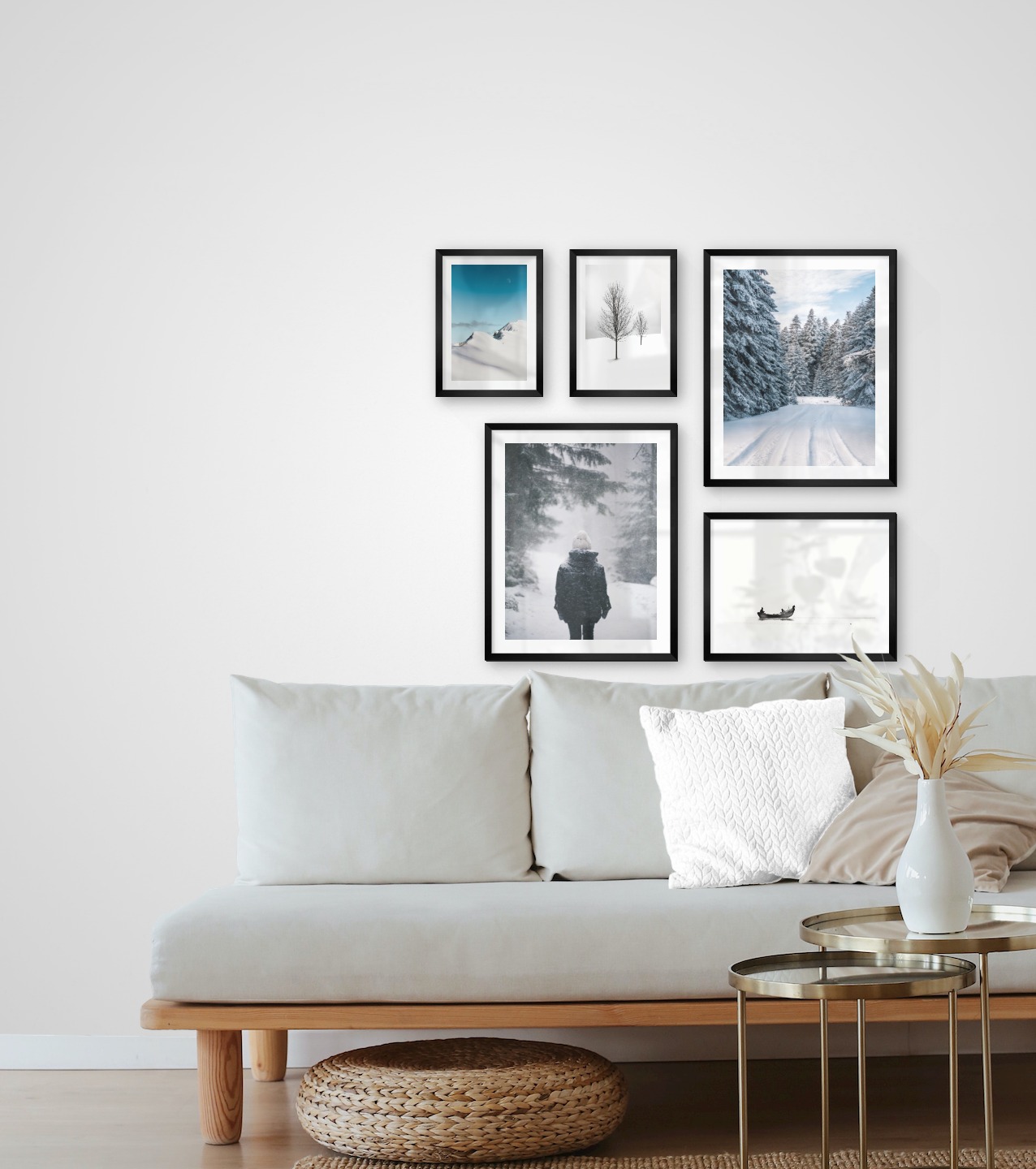 Gallery wall with picture frames in black in sizes 21x30, 40x50 and 30x40 with prints "Trees in the snow", "Snowy mountain peaks", "Person in the snow", "Snowy road" and "People in boat"