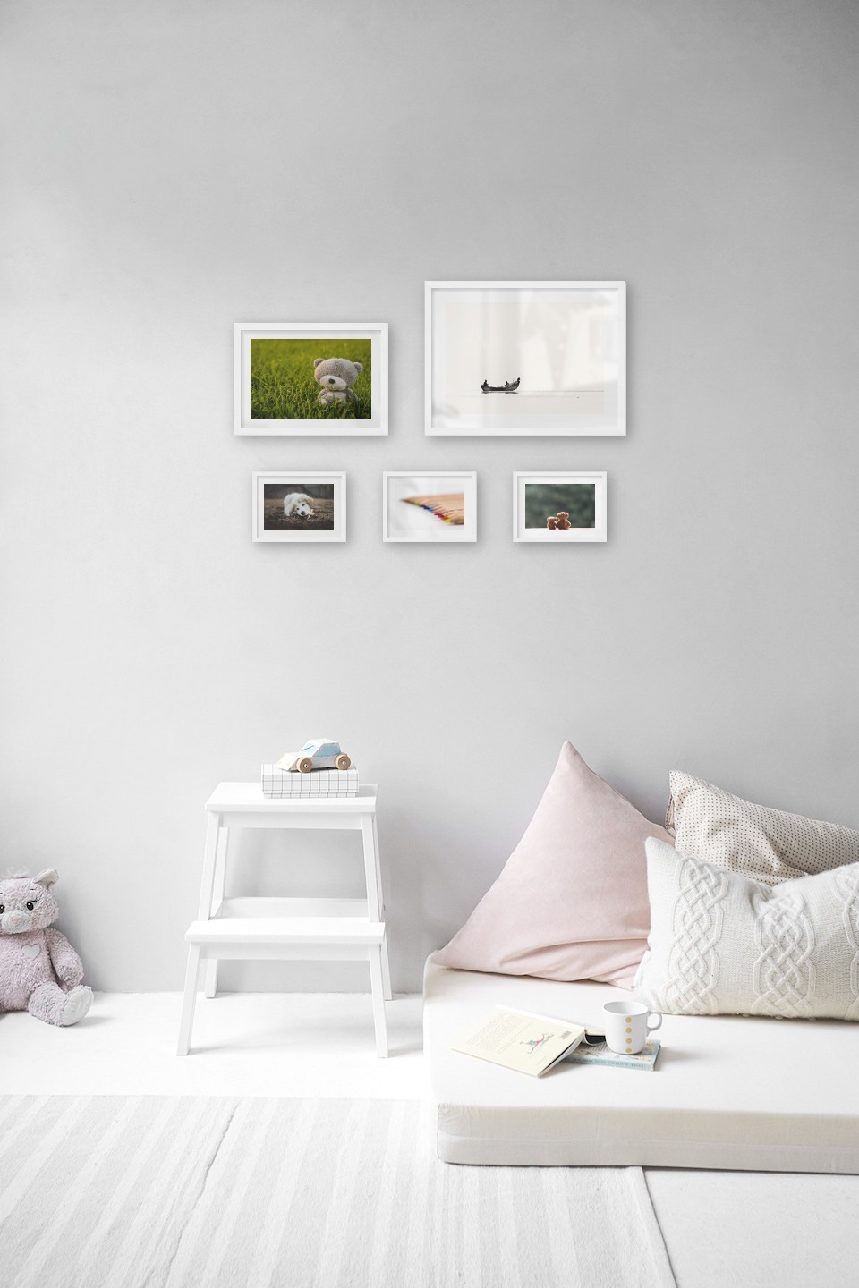 Gallery wall with picture frames in white in sizes 21x30, 30x40 and 13x18 with prints "Teddy bear in a field", "People in boat", "Dog chewing", "Pencils in different colors" and "Teddy bears and greenery"