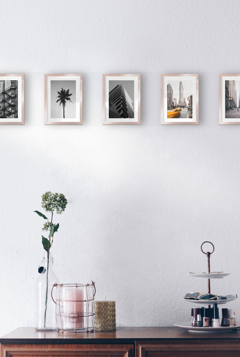 Gallery wall with picture frames in copper in sizes 13x18 with prints "Stairs on the facade", "Palm", "Black and white building", "Yellow taxis in town" and "Man walking across the street"