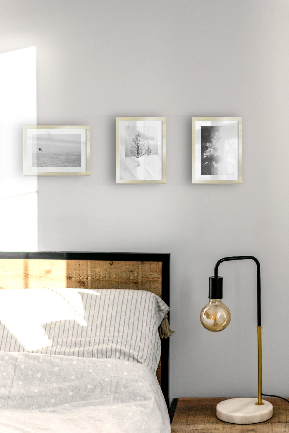 Gallery wall with picture frames in gold in sizes 13x18 with prints "Tall trees", "Birds over the sea", "Trees in the snow" and "Foggy wooden tops from the side"