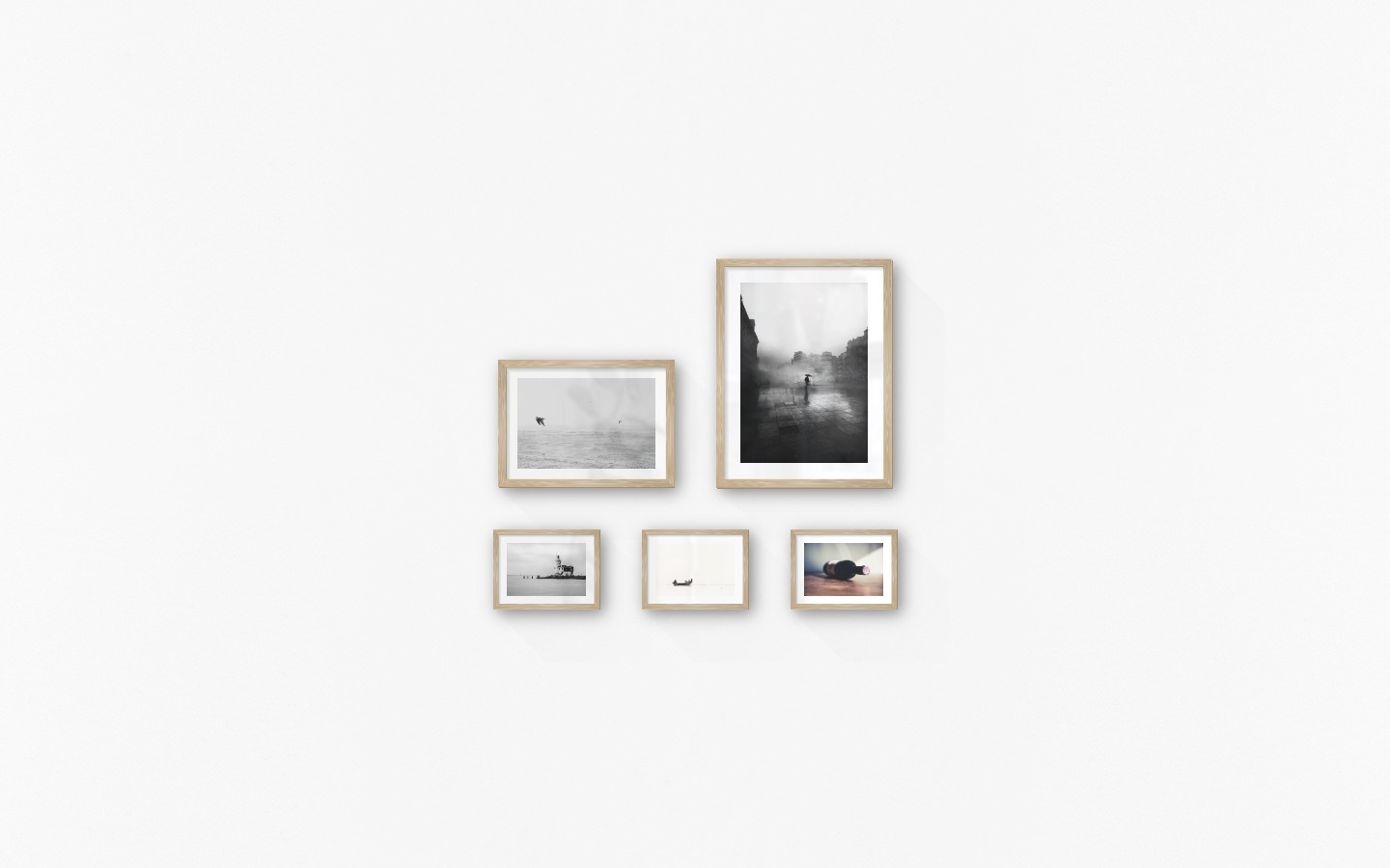 Gallery wall with picture frames in wood in sizes 21x30, 30x40 and 13x18 with prints "Birds over the sea", "Rainy city", "Pier with building", "People in boat" and "Wine bottle on table"