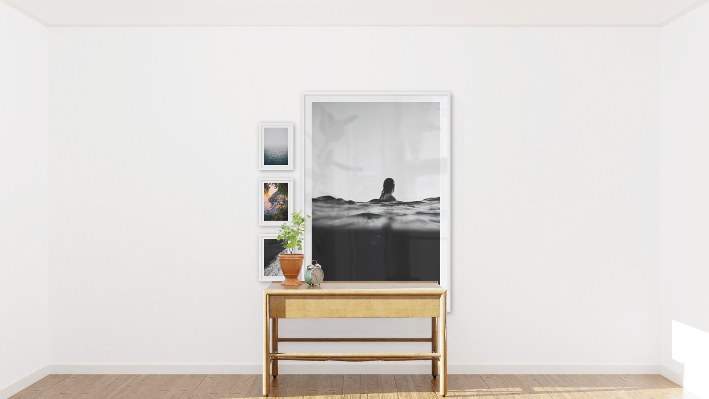 Gallery wall with picture frames in white in sizes 21x30 and 100x150 with prints "Fog over the sea", "City by the sea", "Swell from waves" and "Person in the water"