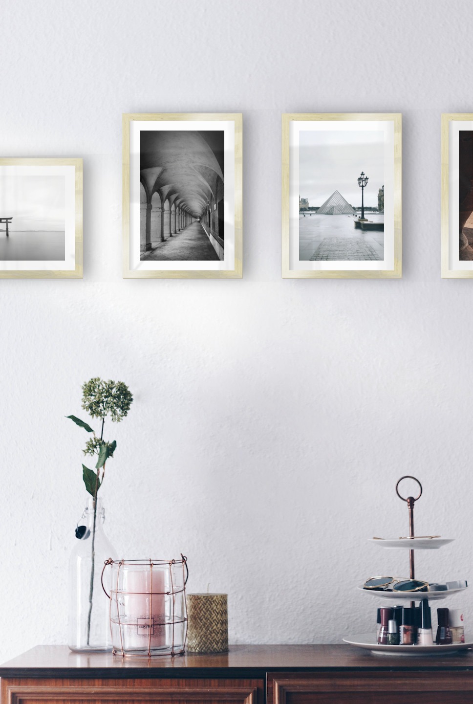Gallery wall with picture frames in gold in sizes 21x30 with prints "Pillars in the water", "Hallway with pillars and arches", "Louvre in Paris" and "Petra in Jordan"
