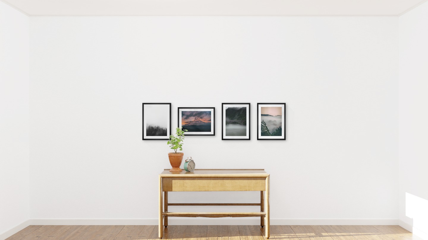 Gallery wall with picture frames in black in sizes 30x40 with prints "Foggy wooden tops", "Sunset and mountains", "Train over bridge" and "Wooden tops and orange sky"