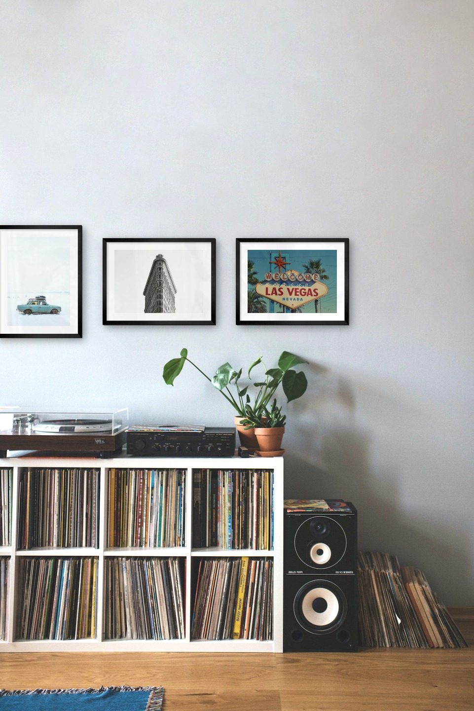 Gallery wall with picture frames in black in sizes 30x40 with prints "Guitar", "Car in snow", "Triangular building" and "Las Vegas sign"