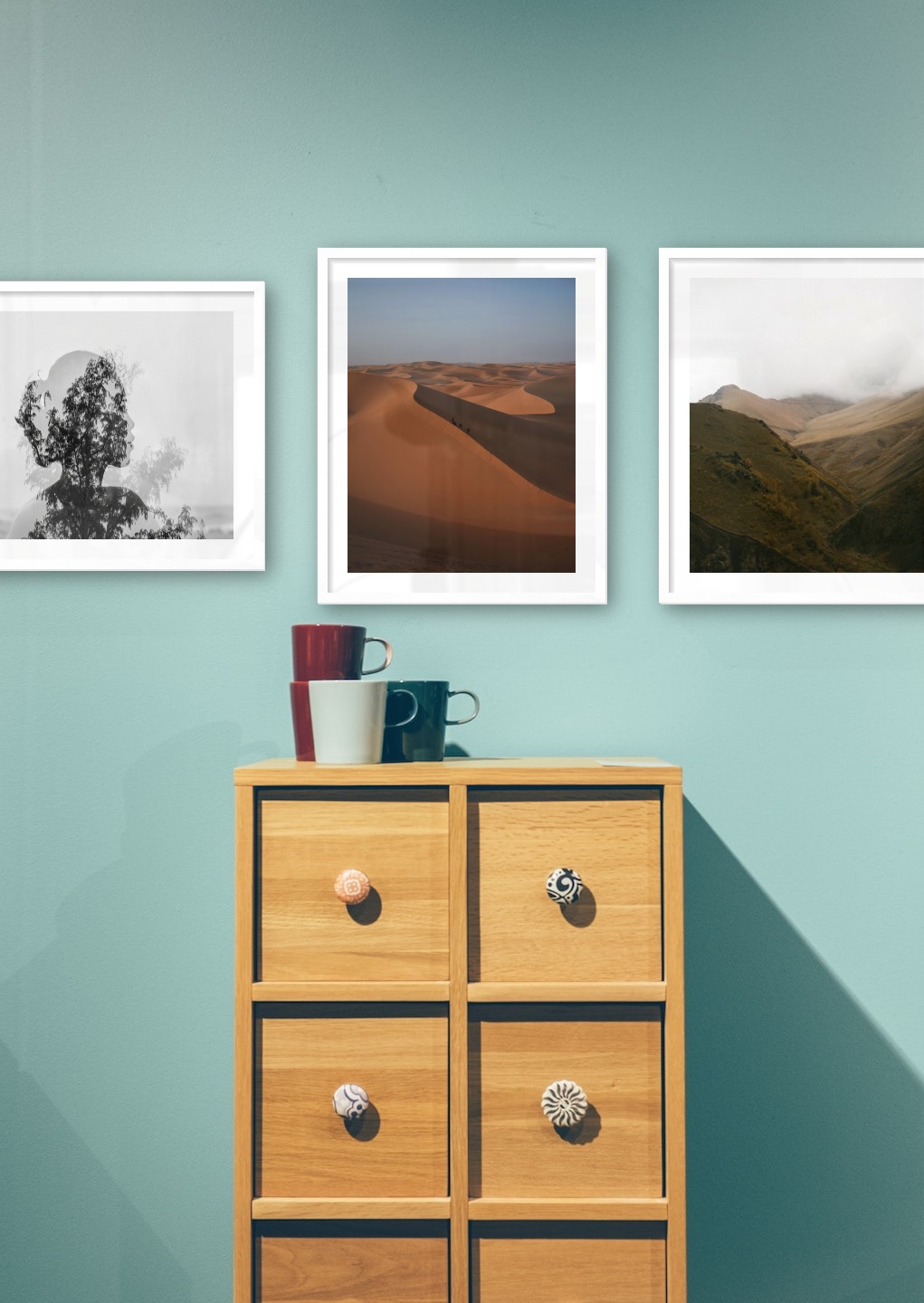 Gallery wall with picture frames in white in sizes 40x50 and 50x50 with prints "Trees and silhouette", "Desert" and "Foggy valley"