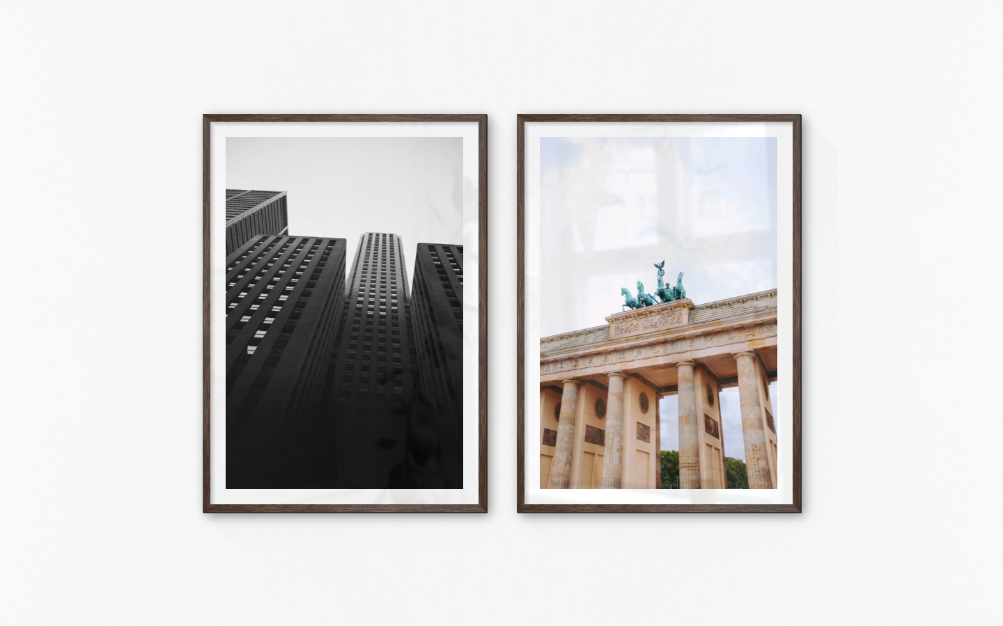Gallery wall with picture frames in dark wood in sizes 70x100 with prints "High buildings" and "Berlin"