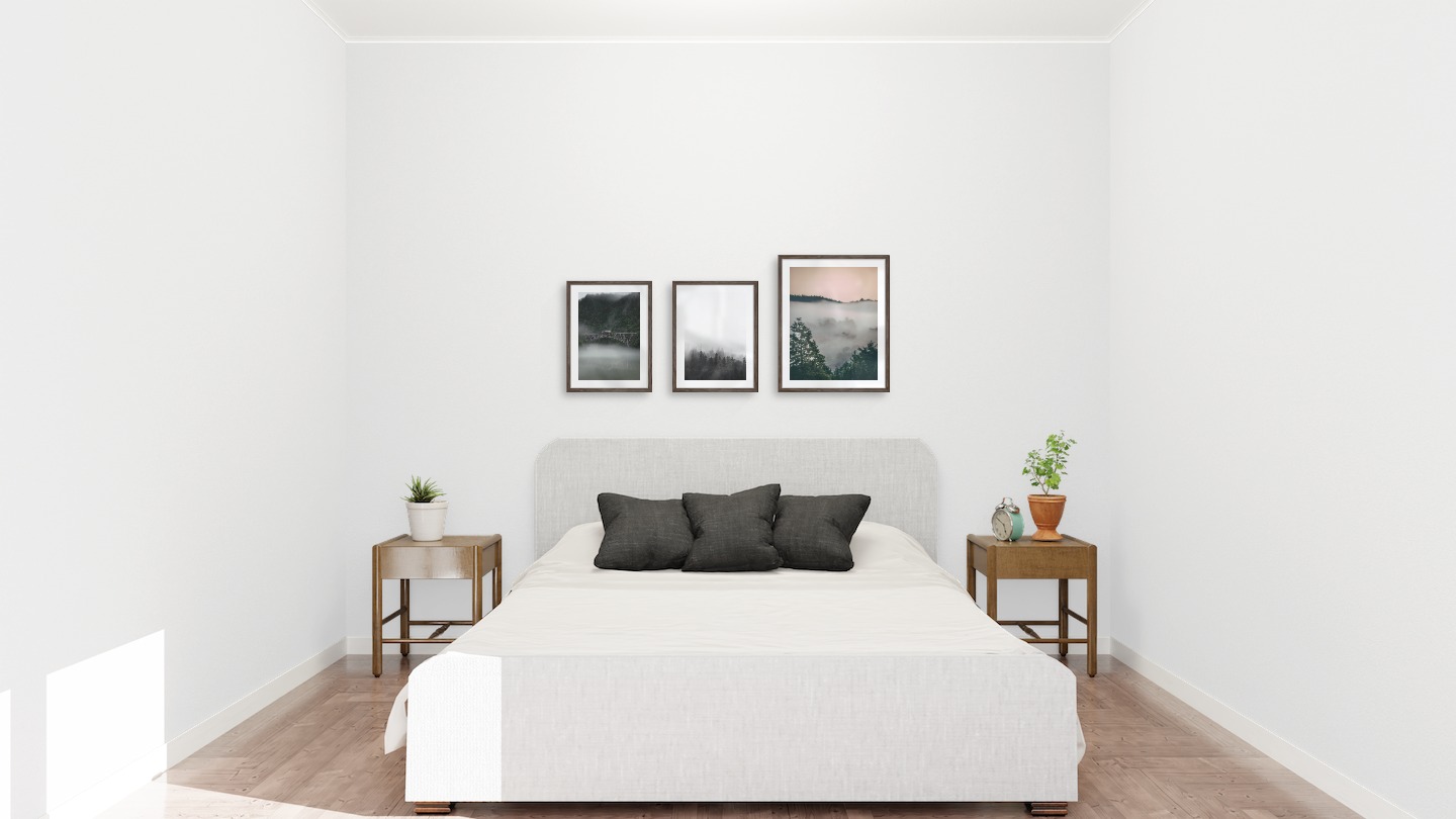 Gallery wall with picture frames in dark wood in sizes 30x40 and 40x50 with prints "Train over bridge", "Foggy wooden tops" and "Wooden tops and orange sky"