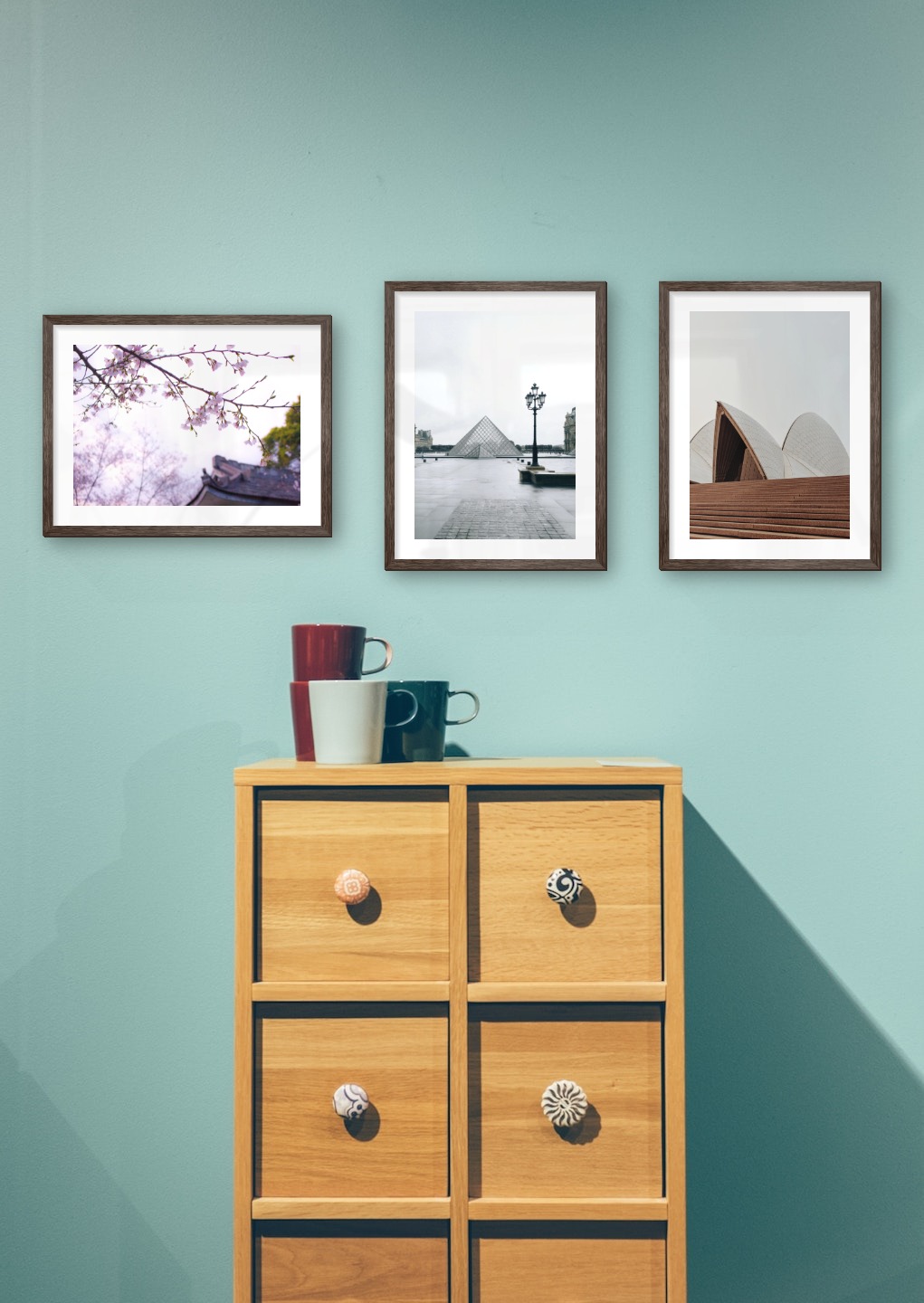 Gallery wall with picture frames in dark wood in sizes 30x40 with prints "Flowers in Tokyo", "Louvre in Paris" and "Sydney Opera House"