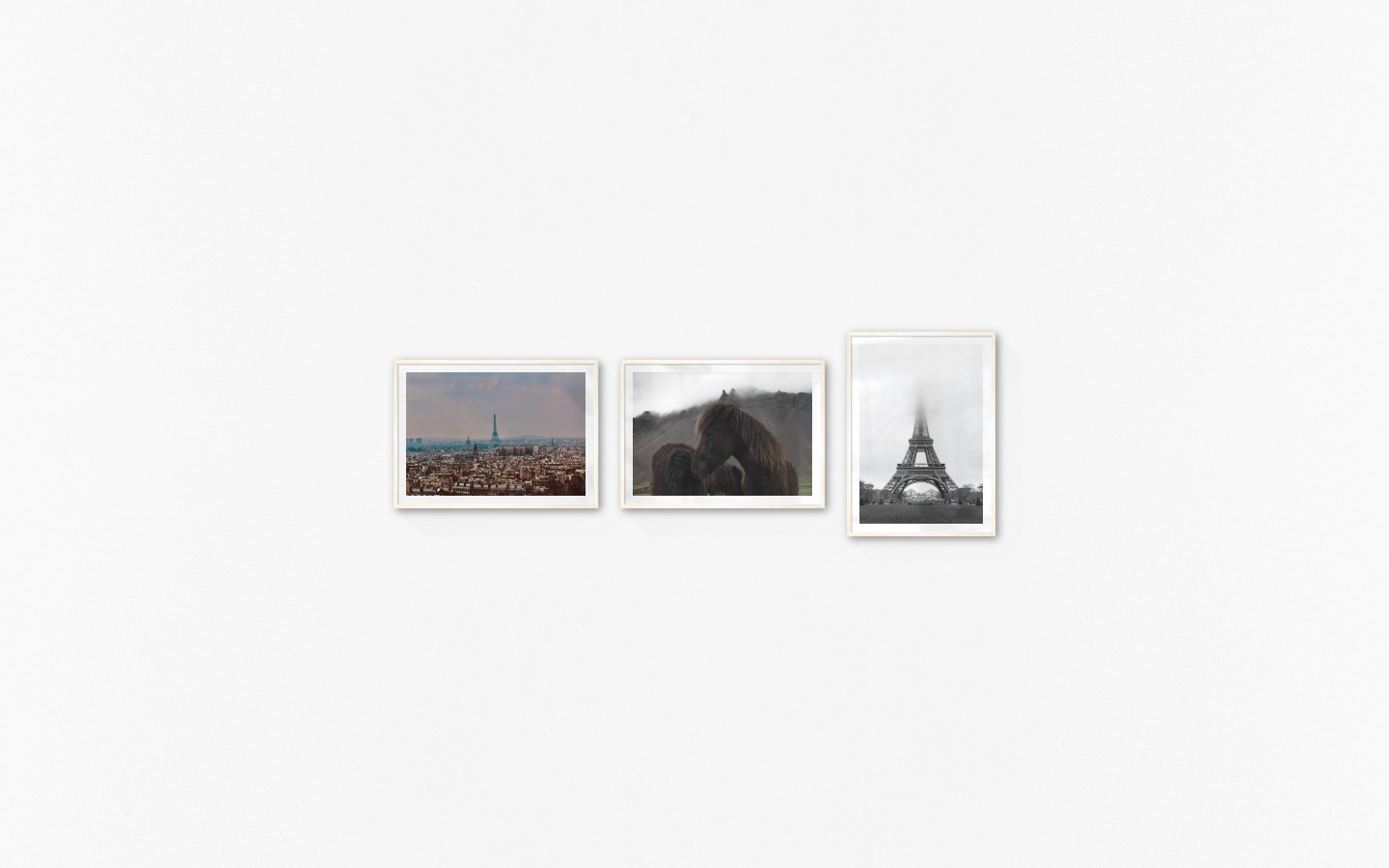 Gallery wall with picture frames in light wood in sizes 50x70 with prints "Eifel Tower in Paris", "Icelandic horses" and "Eifel tower with fog"