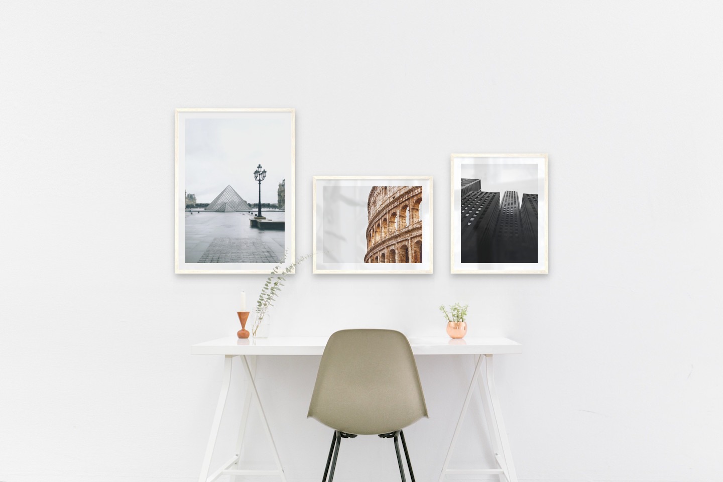Gallery wall with picture frames in light wood in sizes 50x70 and 40x50 with prints "Louvre in Paris", "Colosseum and Rome" and "High buildings"