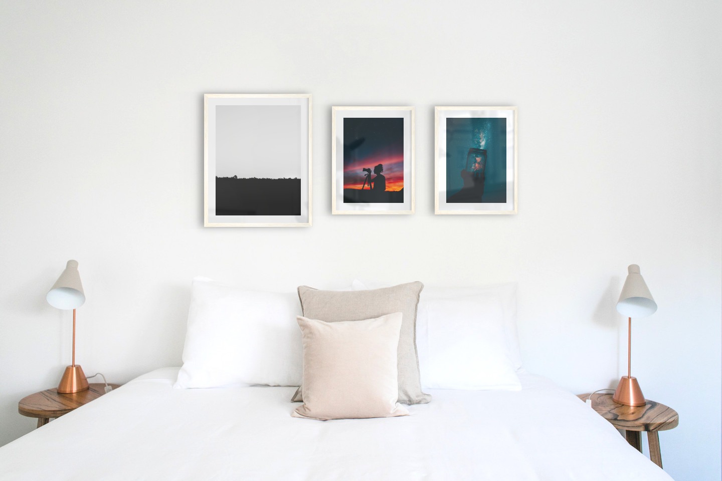 Gallery wall with picture frames in light wood in sizes 40x50 and 30x40 with prints "Sky above trees", "Photographer at night" and "Jar in front of space"