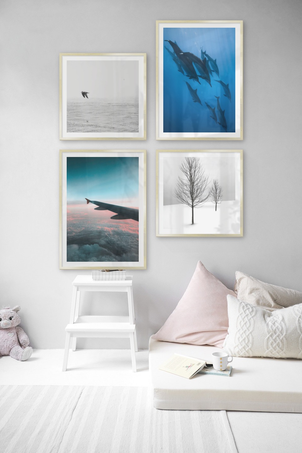 Gallery wall with picture frames in gold in sizes 50x50 and 50x70 with prints "Birds over the sea", "Dolphins", "Above the clouds" and "Trees in the snow"