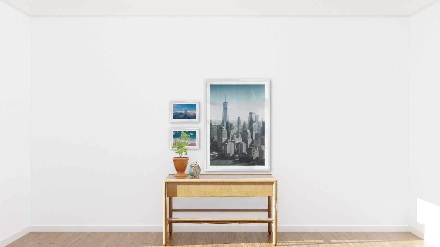Gallery wall with picture frames in silver in sizes 21x30 and 70x100 with prints "Top above the clouds", "Waves on the beach" and "Gray and blue skyline"
