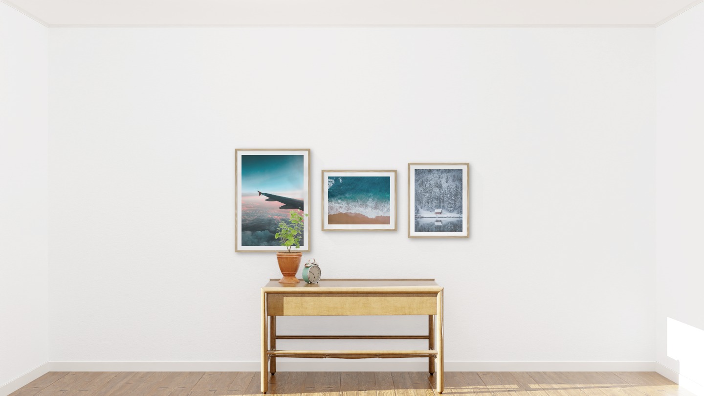 Gallery wall with picture frames in wood in sizes 50x70 and 40x50 with prints "Above the clouds", "Waves on the beach" and "Cottage by the lake"