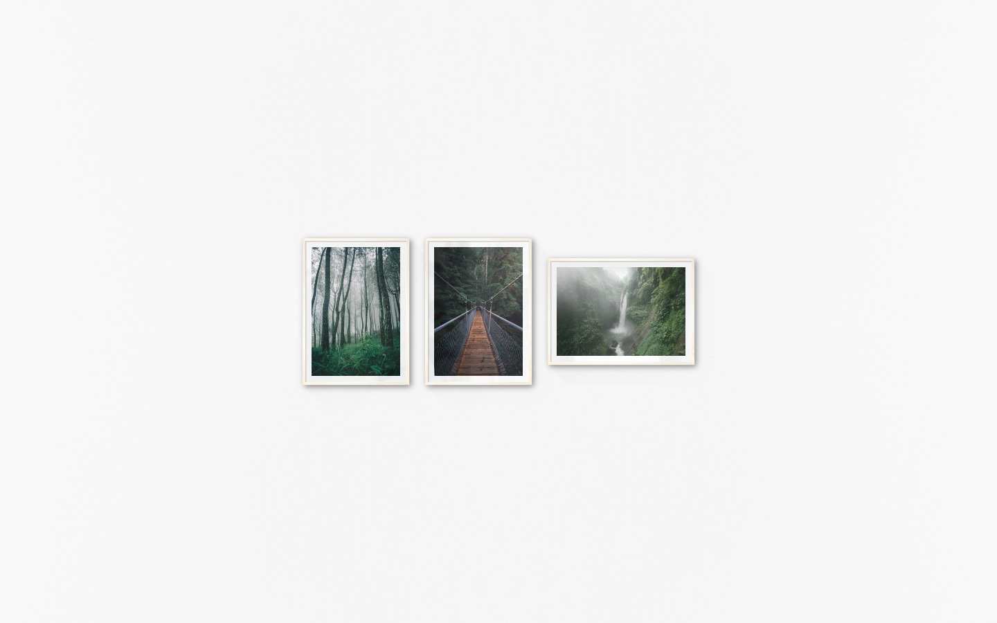 Gallery wall with picture frames in light wood in sizes 50x70 with prints "Tall trees", "Bridge in the woods" and "Waterfall in forest"