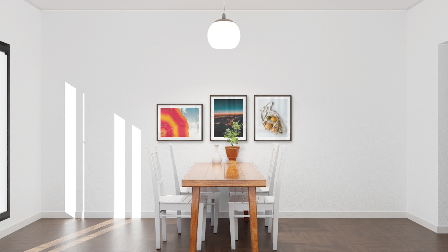 Gallery wall with picture frames in dark wood in sizes 40x50 with prints "Parasol and sky", "City lights on mountains" and "Fruit in a bag"
