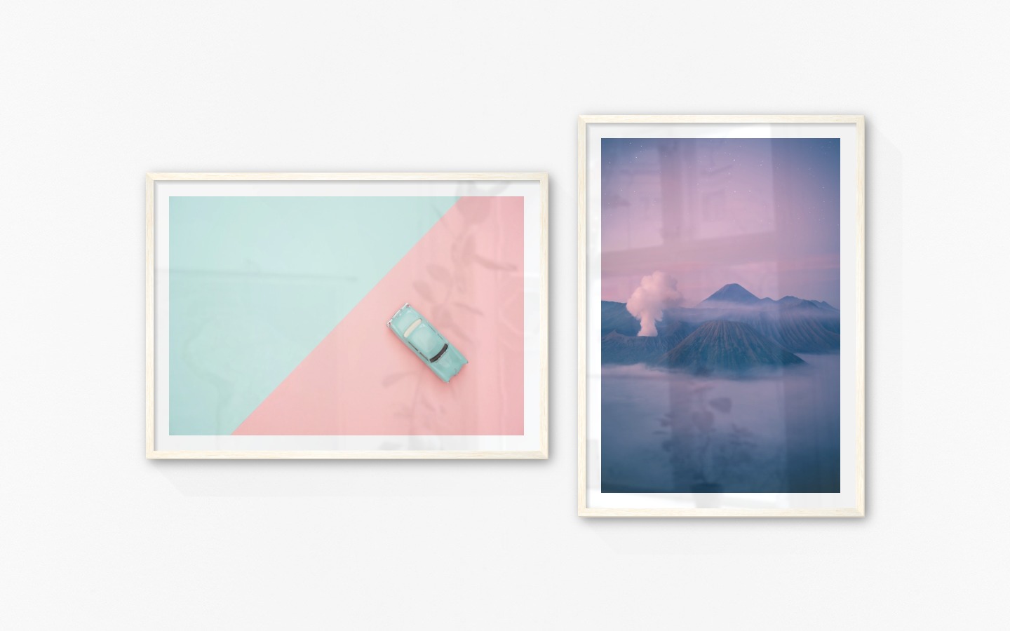 Gallery wall with picture frames in light wood in sizes 70x100 with prints "Blue car and pink" and "Mountains above the clouds"