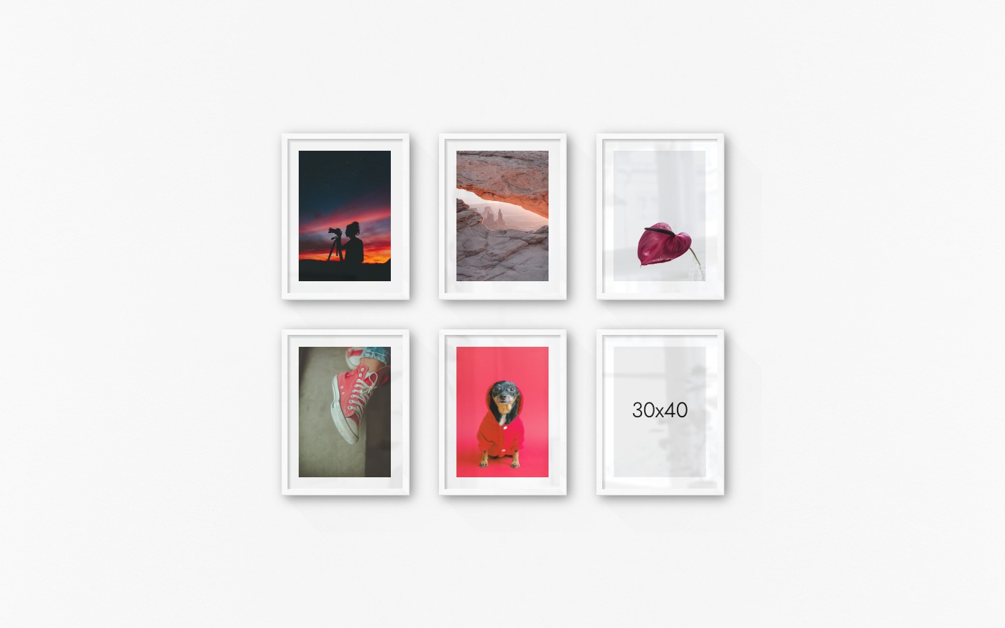 Gallery wall with picture frames in white in sizes 30x40 with prints "Photographer at night", "View between cliffs", "Red flower", "Red shoes" and "Dog in red sweater"