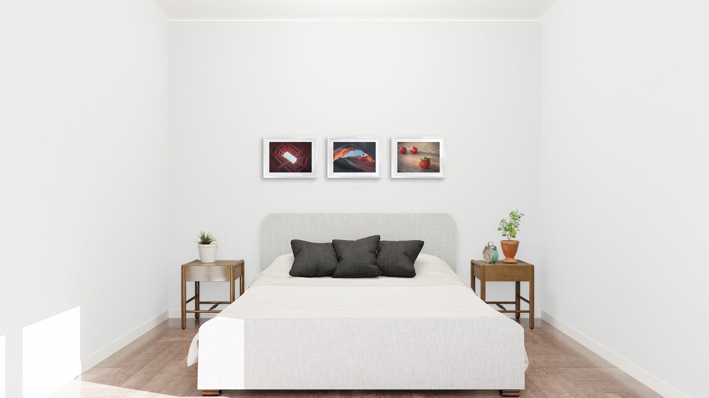 Gallery wall with picture frames in silver in sizes 30x40 with prints "Airplane above building", "Red rock formations" and "Tomatoes"