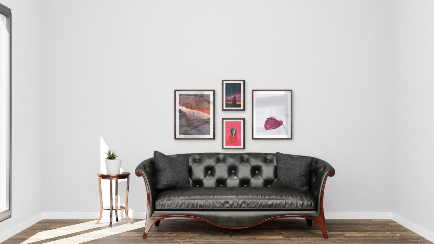 Gallery wall with picture frames in dark wood in sizes 40x50 and 21x30 with prints "View between cliffs", "Dog in red sweater", "Photographer at night" and "Red flower"