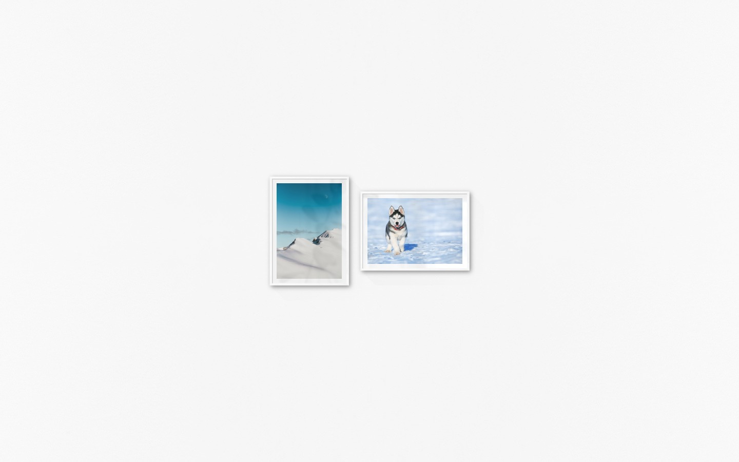 Gallery wall with picture frames in white in sizes 50x70 with prints "Snowy mountain peaks" and "Husky"
