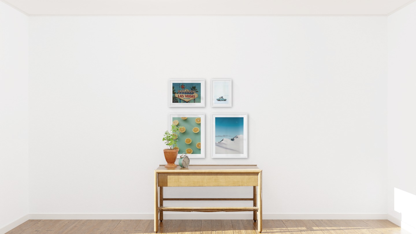 Gallery wall with picture frames in white in sizes 40x50, 30x40 and 21x30 with prints "Lemons", "Snowy mountain peaks", "Las Vegas sign" and "Car in snow"