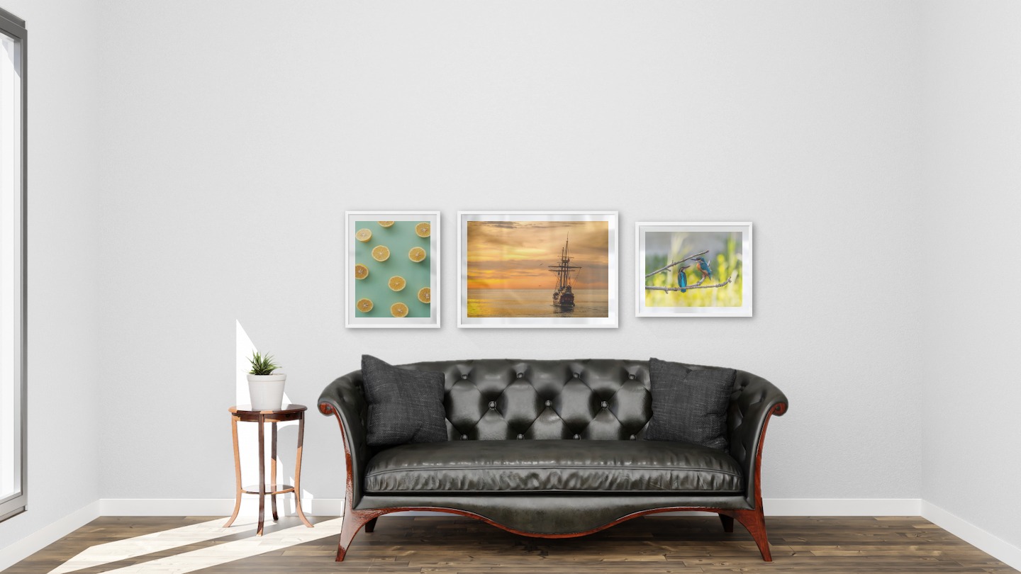 Gallery wall with picture frames in white in sizes 40x50 and 50x70 with prints "Lemons", "Ships at sea" and "Hummingbirds"