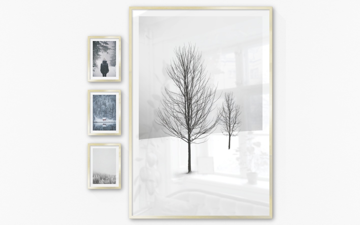 Gallery wall with picture frames in gold in sizes 21x30 and 100x150 with prints "Person in the snow", "Cottage by the lake", "Wooden tops in winter" and "Trees in the snow"