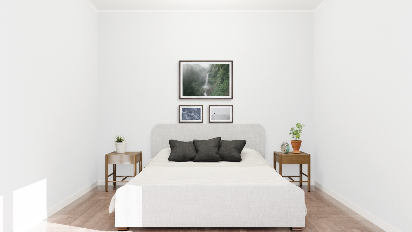 Gallery wall with picture frames in dark wood in sizes 50x70 and 21x30 with prints "Waterfall in forest", "Snowy treetops" and "Birds over the sea"