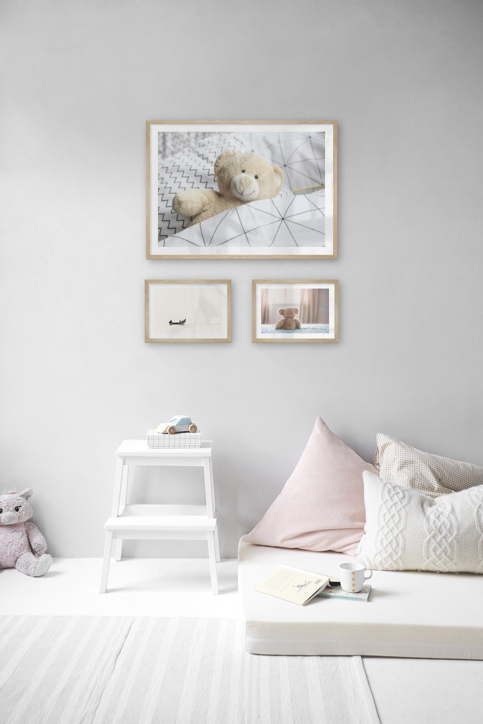 Gallery wall with picture frames in wood in sizes 50x70 and 21x30 with prints "Teddy bear in bed", "People in boat" and "Teddy bear in front of window"