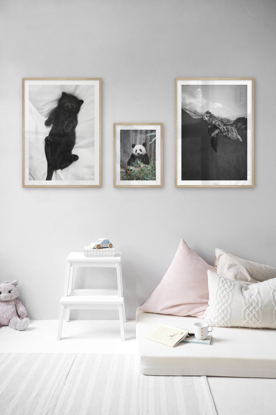 Gallery wall with picture frames in wood in sizes 50x70 and 30x40 with prints "Cat in bed", "Panda" and "Turtle"