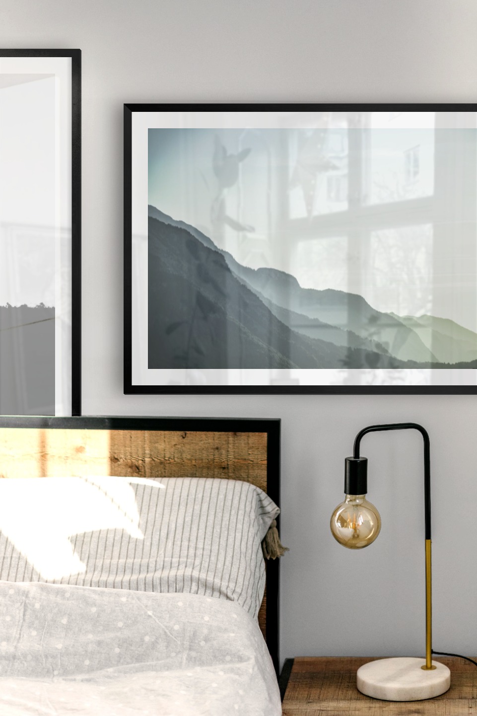 Gallery wall with picture frames in black in sizes 50x70 with prints "Sky above trees" and "Foggy mountain"