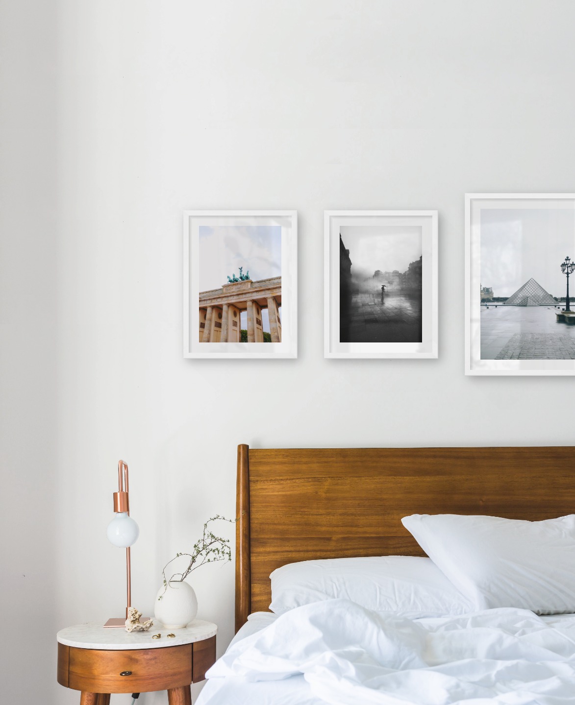 Gallery wall with picture frames in white in sizes 30x40 and 40x50 with prints "Berlin", "Rainy city" and "Louvre in Paris"