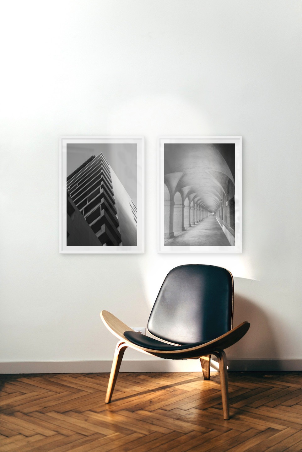 Gallery wall with picture frames in white in sizes 50x70 with prints "Black and white building" and "Hallway with pillars and arches"