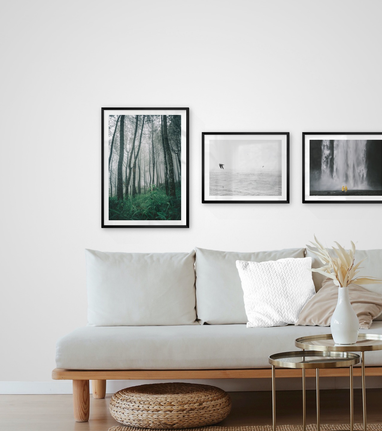Gallery wall with picture frames in black in sizes 50x70 and 40x50 with prints "Tall trees", "Birds over the sea" and "Waterfall with people"