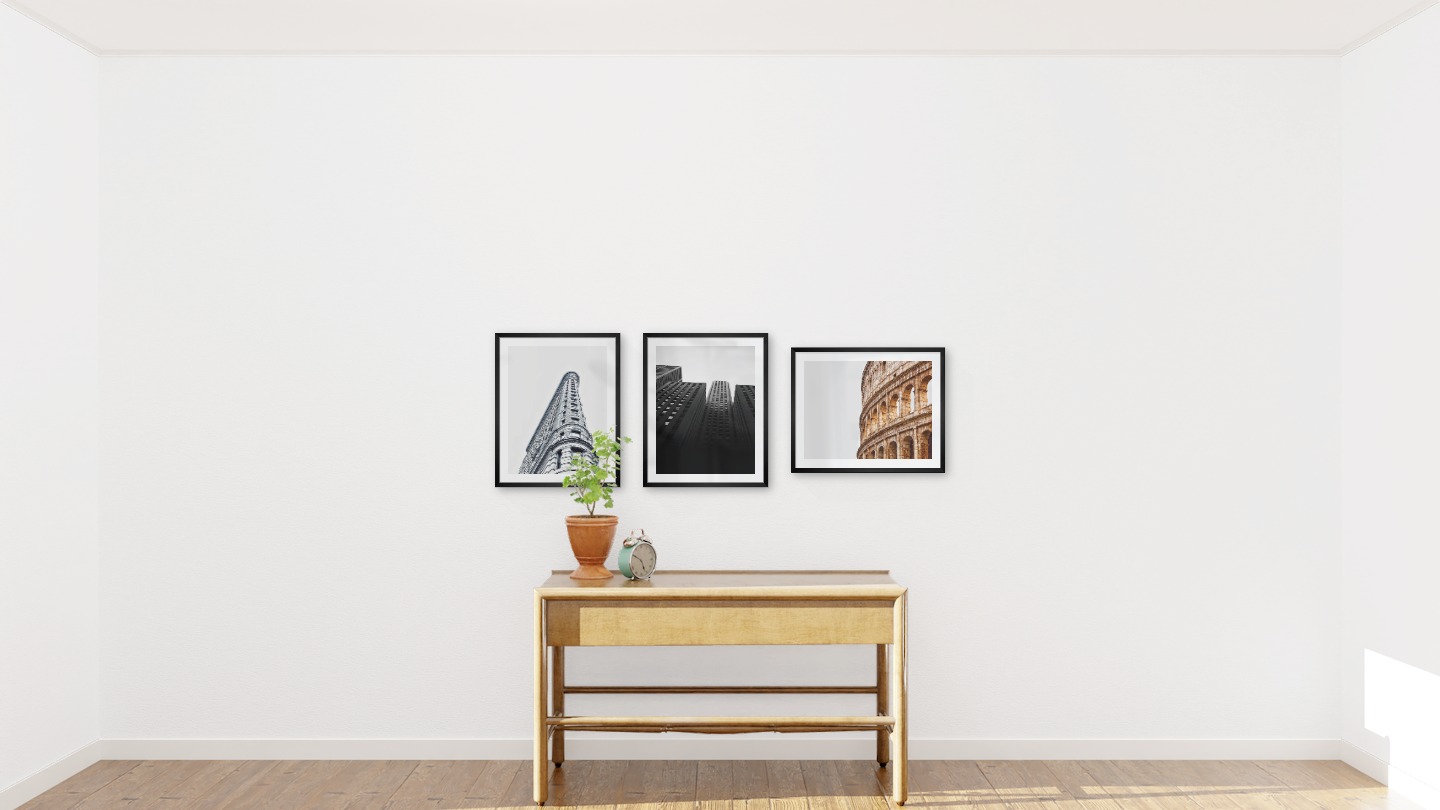 Gallery wall with picture frames in black in sizes 40x50 with prints "Gray building", "High buildings" and "Colosseum and Rome"
