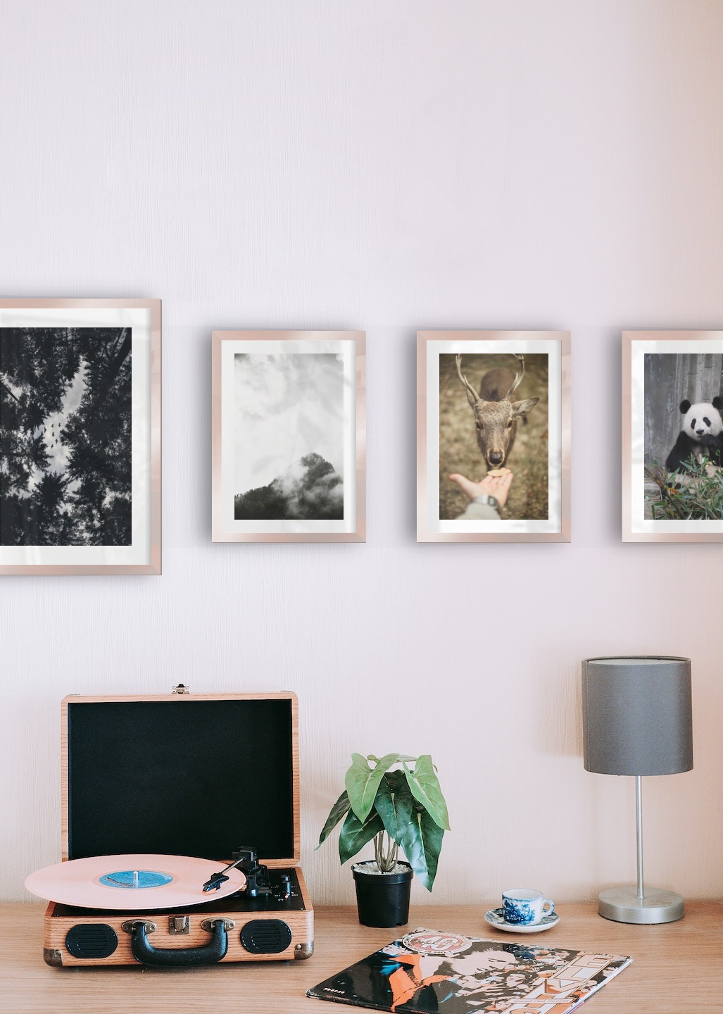 Gallery wall with picture frames in copper in sizes 30x40 and 21x30 with prints "Wooden tops and birds", "Trees and mountains in fog", "Feed a deer" and "Panda"