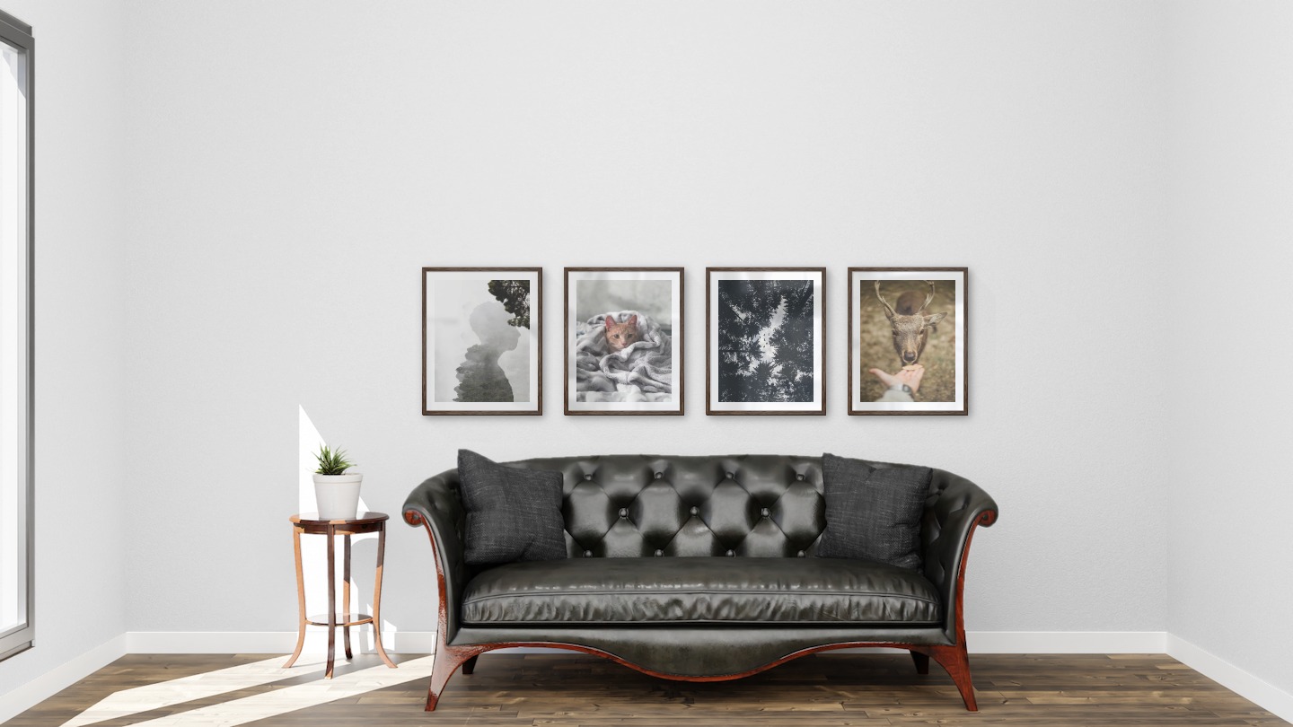 Gallery wall with picture frames in dark wood in sizes 40x50 with prints "Silhouette and tree", "Cat in felt", "Wooden tops and birds" and "Feed a deer"
