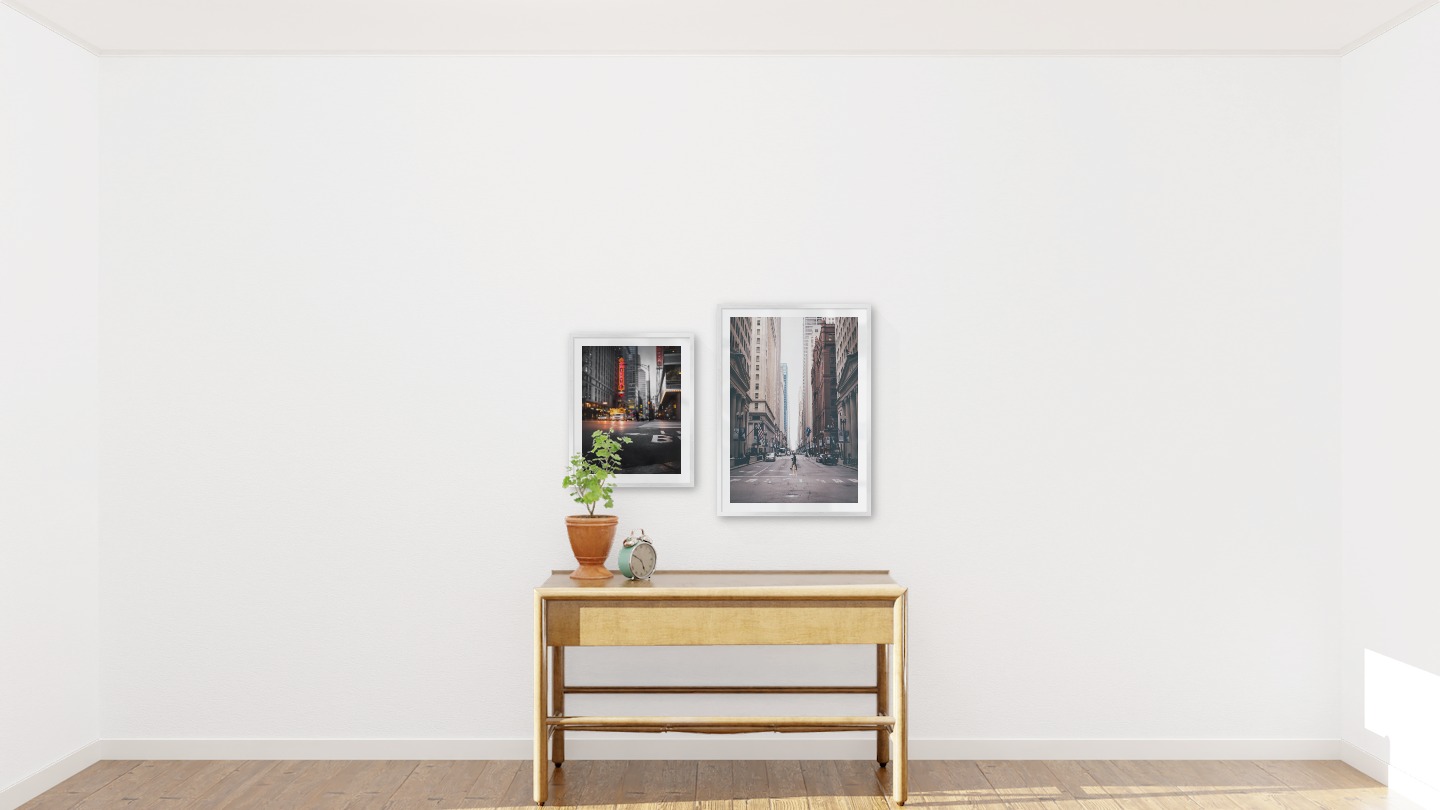 Gallery wall with picture frames in silver in sizes 40x50 and 50x70 with prints "Busy city center" and "Man walking across the street"