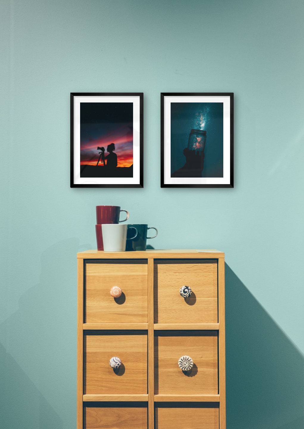 Gallery wall with picture frames in black in sizes 30x40 with prints "Photographer at night" and "Jar in front of space"