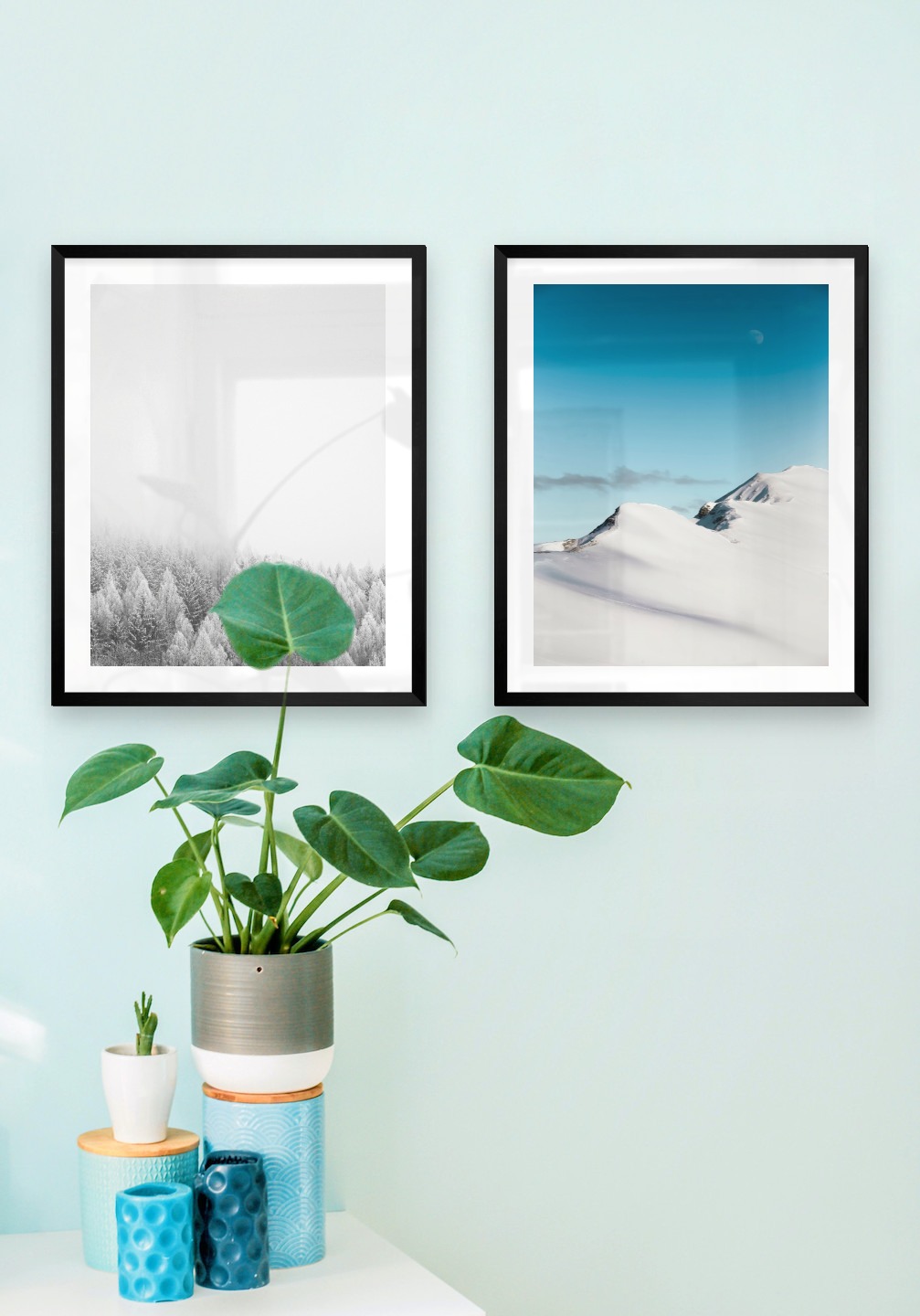 Gallery wall with picture frames in black in sizes 40x50 with prints "Wooden tops in winter" and "Snowy mountain peaks"