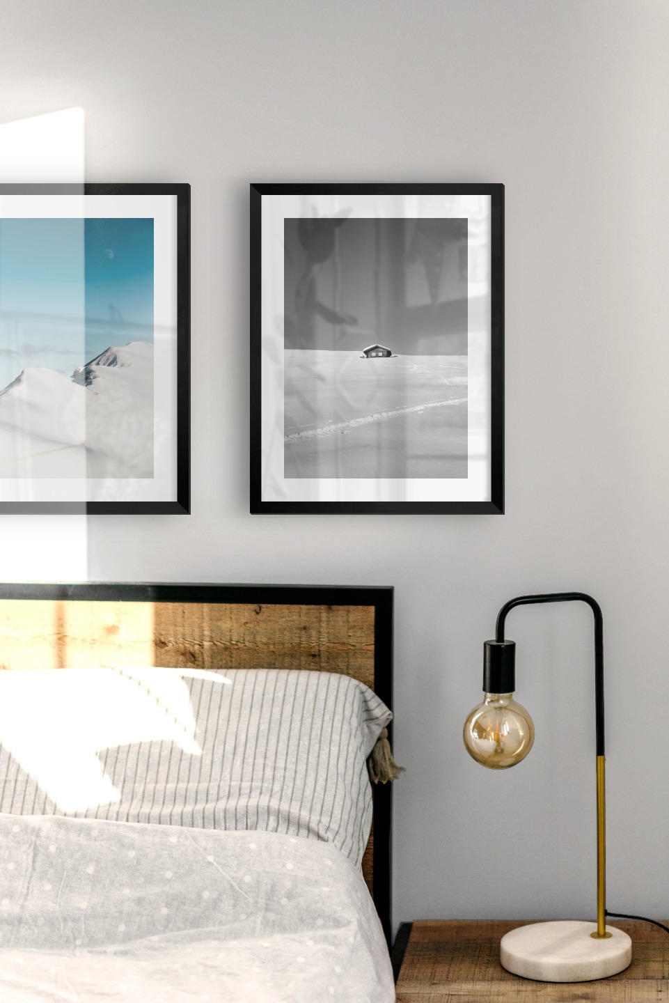 Gallery wall with picture frames in black in sizes 30x40 with prints "Snowy mountain peaks" and "Cottage in the snow"